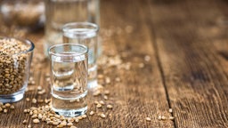 Korn in einem Glas mit Weizenkörnern daneben