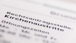 Ein Hinweisschild mit der Aufschrift "Kirchenaustritte" hängt vor der Rechtsantragsstelle im Oberlandesgericht. 