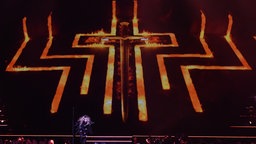 Ein riesiges flammendes Kreuz prägt das Bühnenbild bei einem Madonna-Konzert in Berlin 