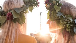 Frauen mit Blumenkränzen im Haar an Mittsommer