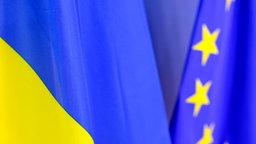 Die ukrainische und die europäische Fahnen wehen nebeneinander.