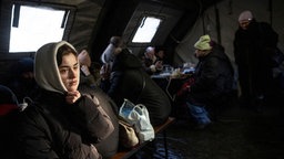 Menschen, deren Zuhause durch Bombenangriffe nicht mehr beheizbar ist, wärmen sich in einem Zelt auf, Kiew, Ukraine, 20.01.2026.