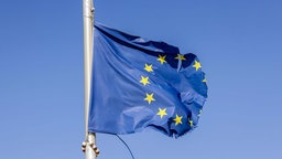 Zerrissene Europafahne flattert am Fahnenmast im Wind. 