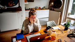 working from home burnout anxiety stress a woman is looking for a job and has her hands in her hair