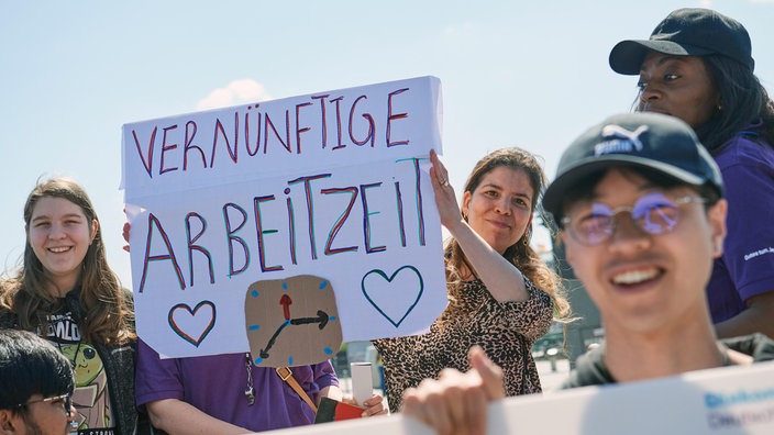 Teilnehmer einer Demonstration für bessere Bedingungen in der Pflege in Berlin am 12. Mai 2023 - ein Plakat zeigt die Worte "Vernünftige Arbeitszeit"