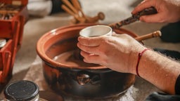 In einer spirituellen Zeremonie füllt ein Schamane eine Tasse mit reinem Kakao