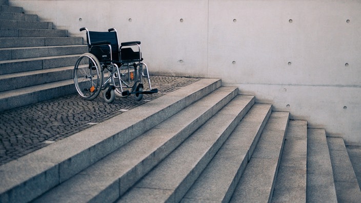 Rollstuhl steht auf einem Treppenabsatz