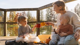 Mutter trinkt Kakao mit zwei Kindern