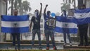 Vermummte Demonstranten halten die Fahne Nicaraguas, sowei ein Foto des getöteten Studenten Matt Romero in Managua hoch, Nicaragua, am 21 September 2019.