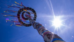 Ein traditioneller Maibaum ragt in den Himmel