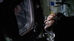 Pilot Victor Glover blickt während der Mondmission "Artemis II" aus dem Fenster der Orionkapsel.