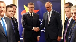 Bundeskanzler Friedrich Merz (CDU, M, r) wird beim EU-Westbalkan-Gipfel von Hristijan Mickoski (M, l), Ministerpräsident von Nordmazedonien, empfangen.