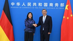 Katherina Reiche (l, CDU), Bundesministerin für Wirtschaft und Energie, schüttelt Wang Wentao, Handelsminister Chinas, die Hand.