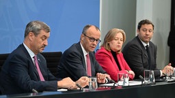 Markus Söder (CSU), Bundesjanzler Merz (CDU), Arbeitsministerin Bärbel Bas (SPD) und FInanzminister und VIzekanzler Lars Klingbeil (SPD) sitzen bei einer Pressekonferenz der Bundesregierung.