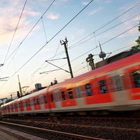 Eine S-Bahn fährt am frühen Morgen Richtung Kölner Innenstadt. Im Hintergrund ist der Fernmeldeturm Colonius zu sehen.