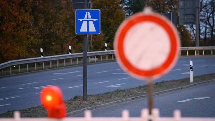 Symbolbild: Vor einem Autobahnhinweis steht ein "Einfahrt-Verboten"-Schild.