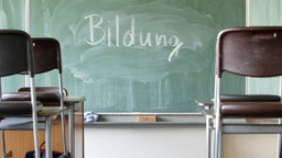 Eine Tafel in einem Klassenraum, auf der mit Kreide das Wort "Bildung" geschrieben wurde. Symbolbild