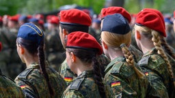Rückansicht: Soldatinnen und Soldaten stehen im Goethepark beim Feierlichen Gelöbnis zusammen