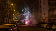 Symbolbild: Eine Feuerwerk zwischen Autos und Mehrfamilienhäusern auf einer Straße in Leipzig (2025).