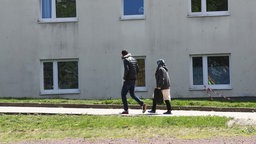 Asylbewerber gehen auf dem Gelände der Erstaufnahmeeinrichtung des Landes Thüringen spazieren.