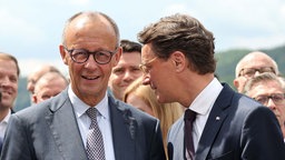 Kanzler Friedrich Merz (links) und NRW-Ministerpräsident Hendrik Wüst, beide CDU, unterhalten sich am 1. Juni 2026 in Mescheide. 