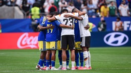 Eine Gruppe von Spieler versammelt sich nach dem Spiel im Mittelkreis und betet gemeinsam: Joshua Brenet (Curacao), Gervane Kastaneer (Curacao), Felix Nmecha (Deutschland) und Jonathan Tah (v.li. Deutschland)