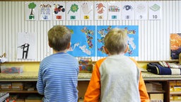 Symbolbild: Rückansicht von zwei Grundschulkindern, die auf Lerntafeln schauen (2014).