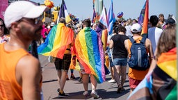 Teilnehmende mit Regenbogenfahnen beim CSD-Umzug
