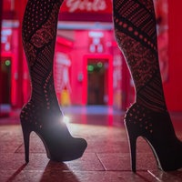 Beine einer Frau in High Heels in einem Bordell, Symbolbild
