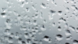 Symbolbild: regen auf einer Fensterscheibe.