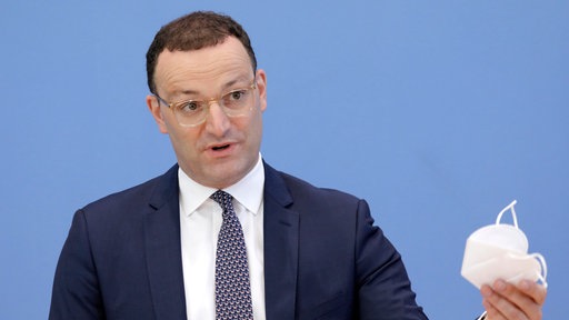 Jens Spahn (bei der Aufnahme Bundesgesundheistminister) hält auf einer Pressekonferenz am 18.06.2021 eine FFP2-Maske hoch