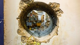 Blick durch ein Loch in der Wand in den Archivraum der Sparkasse Gelsenkirchen.
