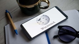 Symbolbild: Wikipedia-Logo auf dem Display eines Smartphones.