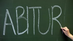 Auf eine grüne Schultafel wurde das Wort "Abitur" mit weißer Kreide geschrieben.
