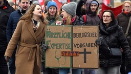 Demonstrantinnen halten Schilder in den Händen, um gegen das Abtreibungsverbot am Klinikum Lippstadt zu protestieren.