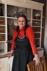 Aida Demirović-Krebs steht mit Kochschürze in einer Küche.