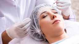 Eine junge Frau lässt sch Botox in die Stirn spritzen