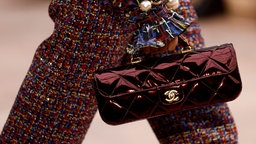 Ein Model präsentiert auf der Fashion Week 2025 eine Tasche des Modehauses Chanel 