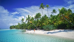 Eine Frau geht am Sandstrand von Aitutaki entlang, einer der Cookinseln.