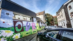 In einem Straßenzug in Dortmund-Dorstfeld ist über mehrere Häuser der Satz "Our colours are beautiful" gesprüht