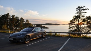 Ein Tesla-Elektroauto steht auf einem Parkplatz an der Küste in Norwegen. 