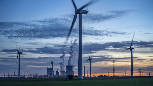 Symbolfoto für Energie-Mix: Im Vordergrund stehen Windräder, im Hintergrund ein Braunkohlekraftwerk.