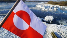 Die Flagge Grönlands vor Schnee.