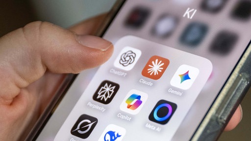 Auf einem Smartphone-Bildschirm sind mehrere KI-Anwendungen zu sehen, darunter ChatGPT, Claude, Gemini, Perplexity, Microsoft Copilot, Meta AI, Grok und DeepSeek. 