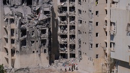 Israelische Gutachter und Freiwillige überprüfen ein beschädigtes Wohnhaus.
