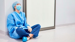 Symbolbild: Eine Ärztin in OP-Kleidung auf einem Krankenhausflur.