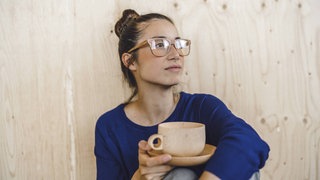 Eine Frau mit einer Tasse Kaffee macht eine Pause.