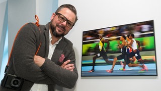 Der Fotograf Kai Pfaffenbach vor einem seiner Fotos