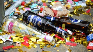 Leere Bierflaschen liegen nach dem Rosenmontagszug auf der Straße.