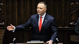 Karol Nawrocki steht am Rednerpult und spricht, dabei unterstreicht er seine Worte mit einer Geste in Richtung Publikum.